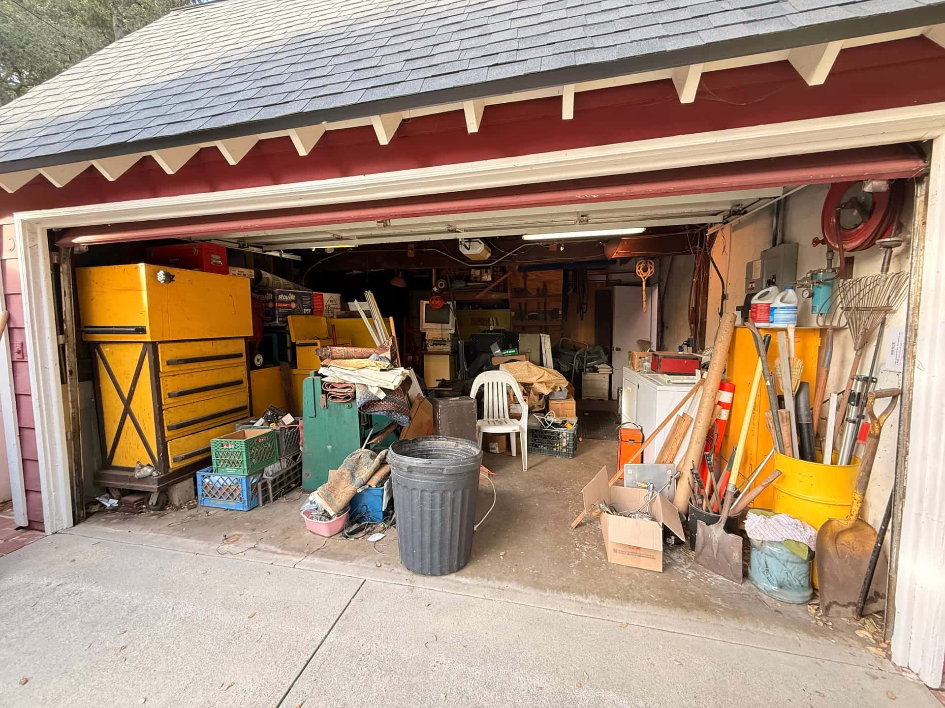 Before: a two-car garage packed with tool chests, crates, bins and old furniture