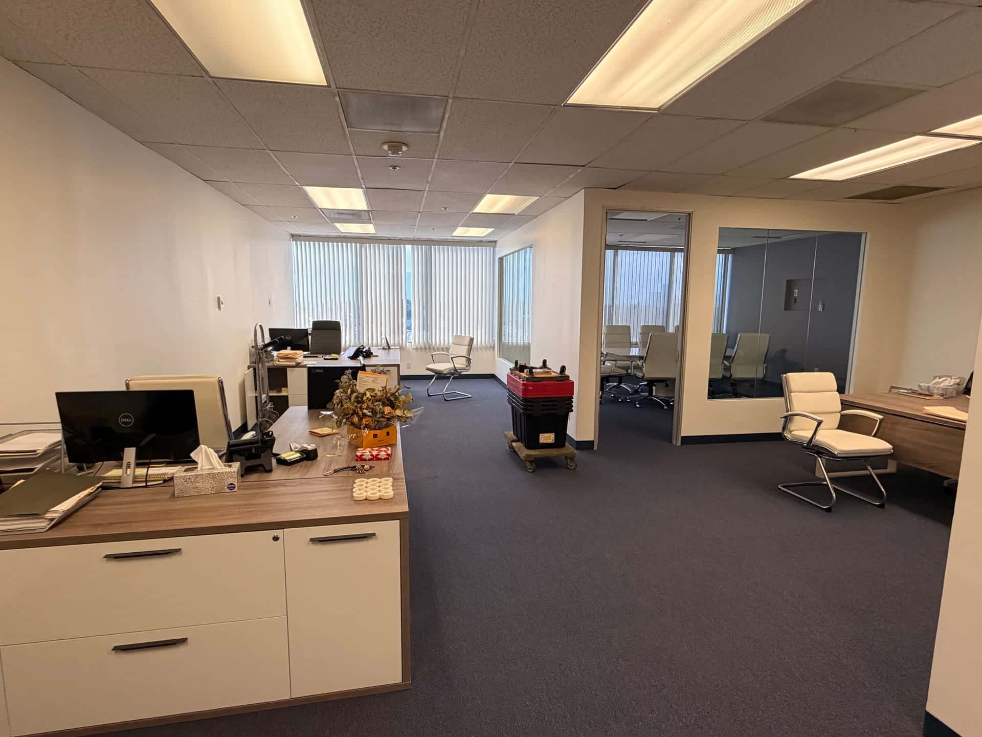 Before: an open-plan office still full of desks, chairs and equipment